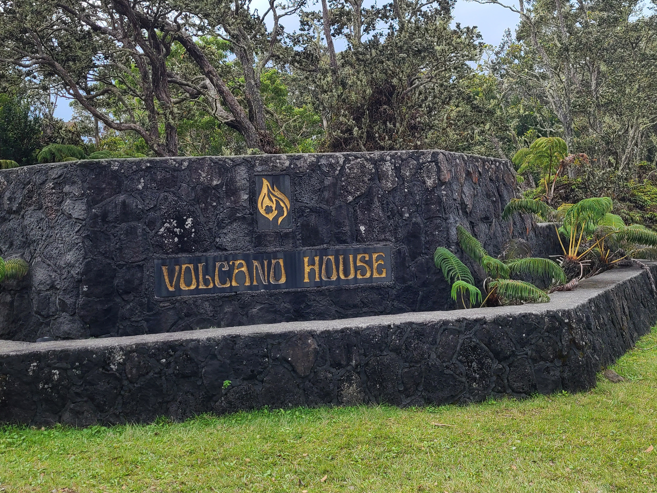 A large rocky sign the reads "Volcano House"